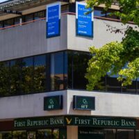 Exterior view of First Republic Bank with leasing signs and temperature display.