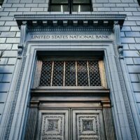 From below classic styled historic building of United States National Bank with wooden doors and vintage lanterns located in Portland